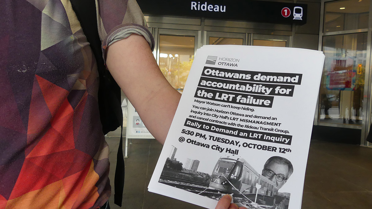 Sam Hersh, a board member with Horizon Ottawa, holds flyers of an upcoming rally.