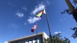 Pride Flag and Canadian flag waving in the wind
