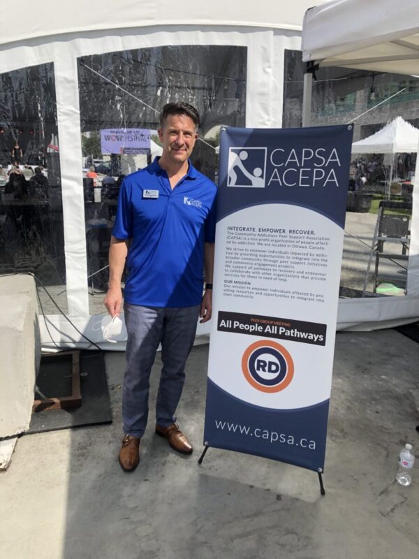 Picture shows Anthony Esposti standing beside CAPSA banner outside Ottawa City Hall.