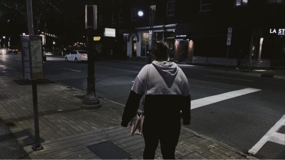 Woman walking alone in the city streets at night.