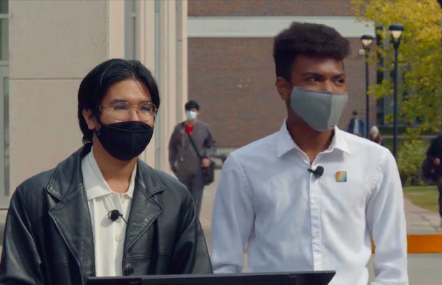 Two students hosting flag raising ceremony on campus.