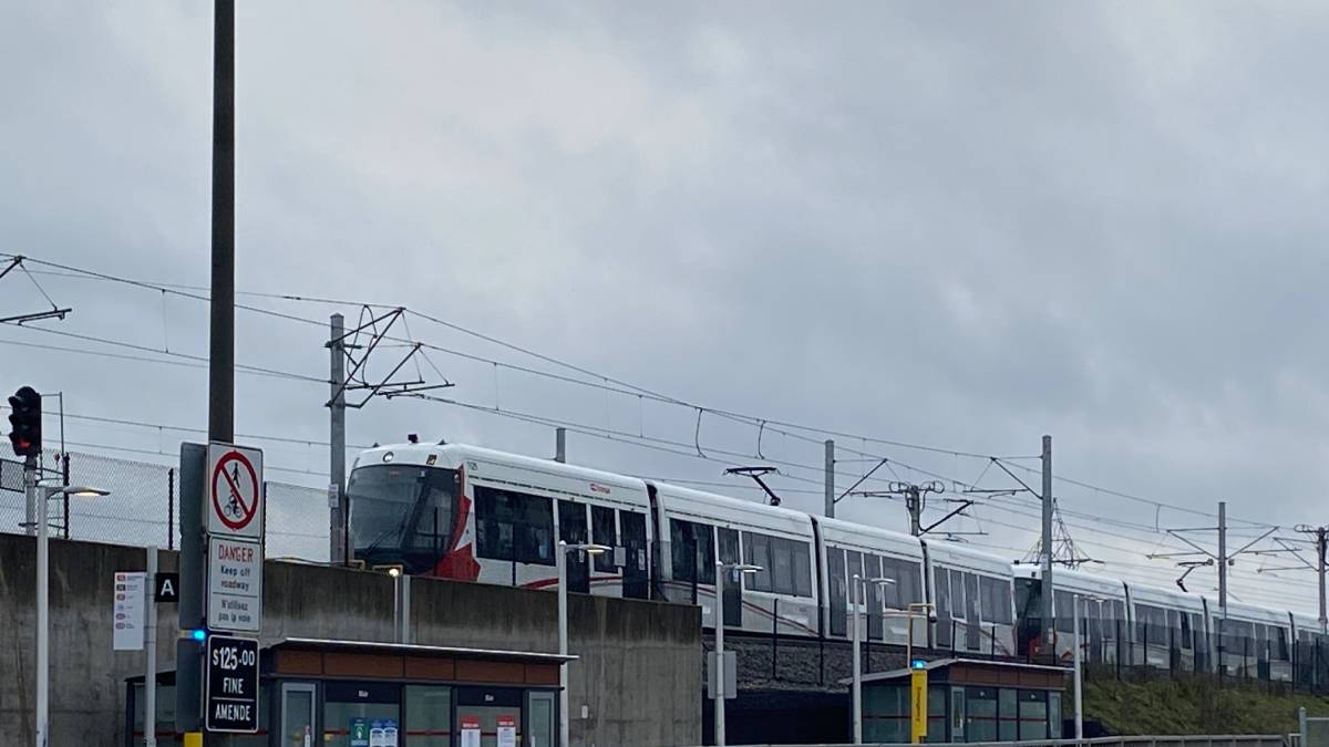 A light-rail train arrives at Blair Station in Ottawa on a cloudy day.