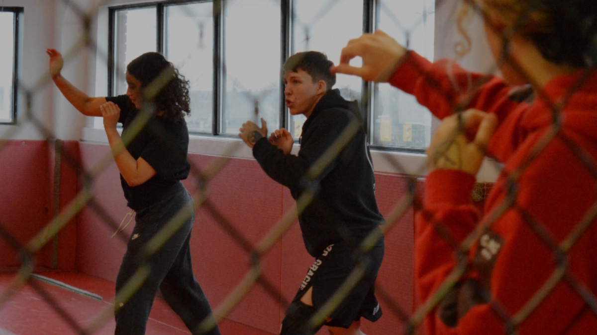 Isabella Griffin on left and Jo Maisonneuve on right. Both are standing in a defensive fighting positive as they instruct a self-defense class. 