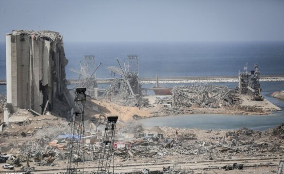 Photo of destroyed building and surrounding blast scene in Beirut with Mediterranean Sea in the background