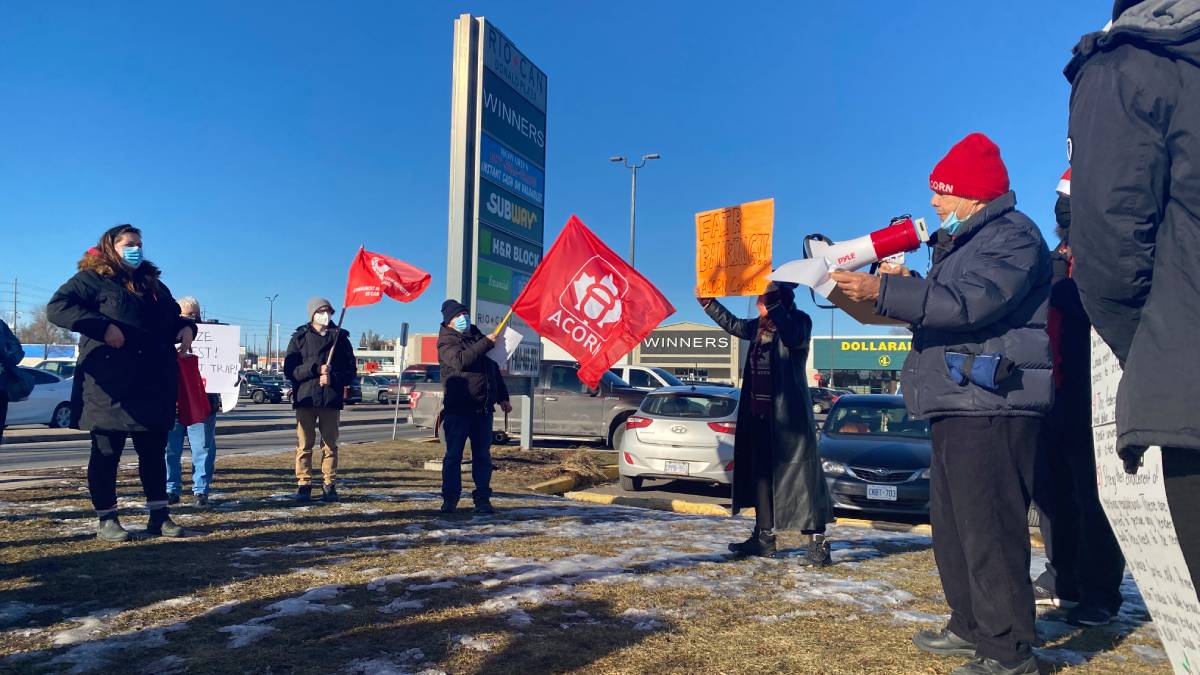 ACORN Vanier chapter chairman, Bader Abu-Zahra speaks through a megaphone to a crowd gathered outside a loan agency where they plan to deliver a letter to the CEO calling for lower interest rates. 