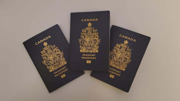 Three Canadian passports are lined up against a white background.