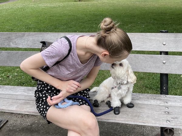 Morgane and Flurry sitting on a bench outside and looking at each.