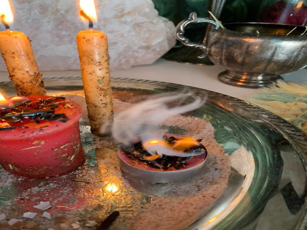 Witchcraft altar adorned by lit candles.