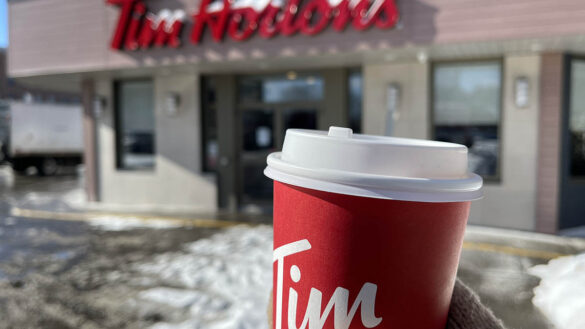 A Tim Hortons coffee cup in front of a Tim Hortons