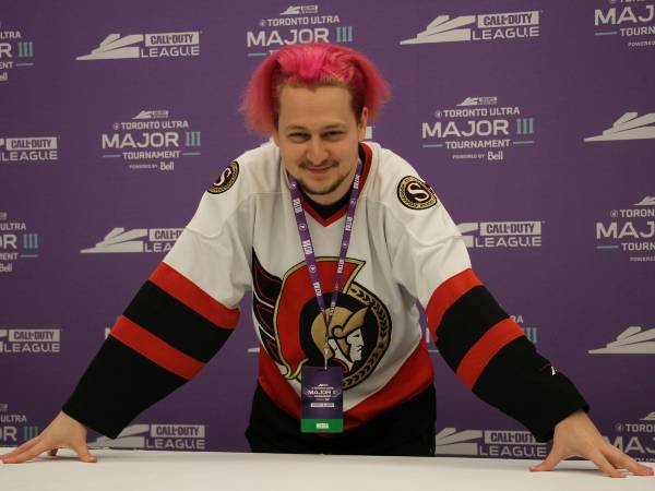 Michael Czarnowski wears a white Ottawa Senators jersey in front of a purple background.