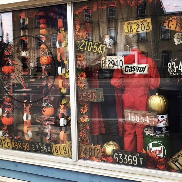 The halloween store front of Claimed Vintage shop. The window is filled with halloween decor and vintage license plates.