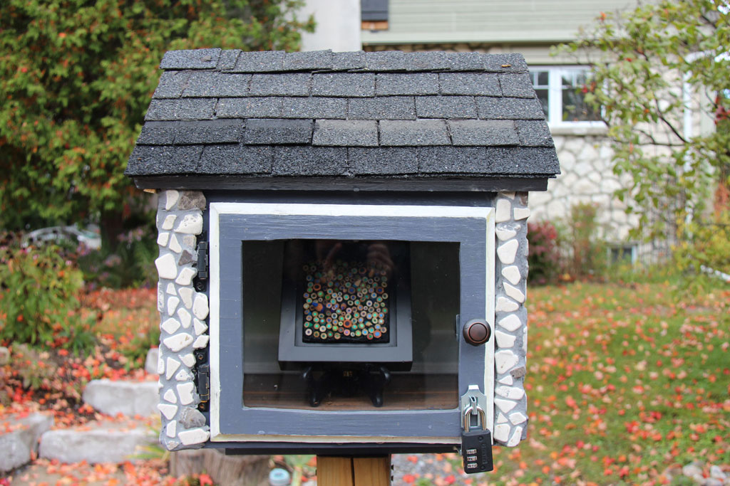 Public art display box, a mosiac made of pencil crayon ends is inside.