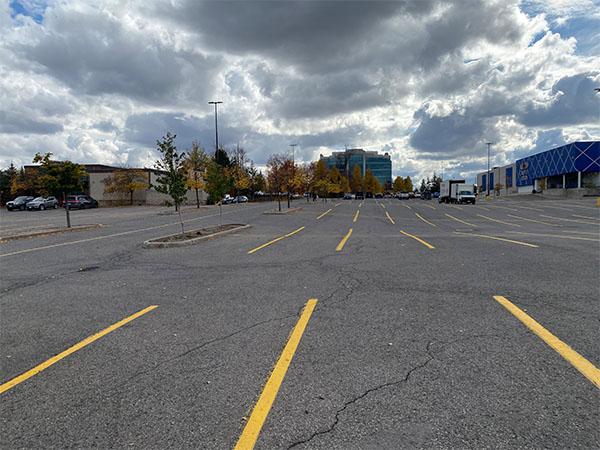 A very uneven parking lot without sidewalks. The parking lot hinders transit accessibility.