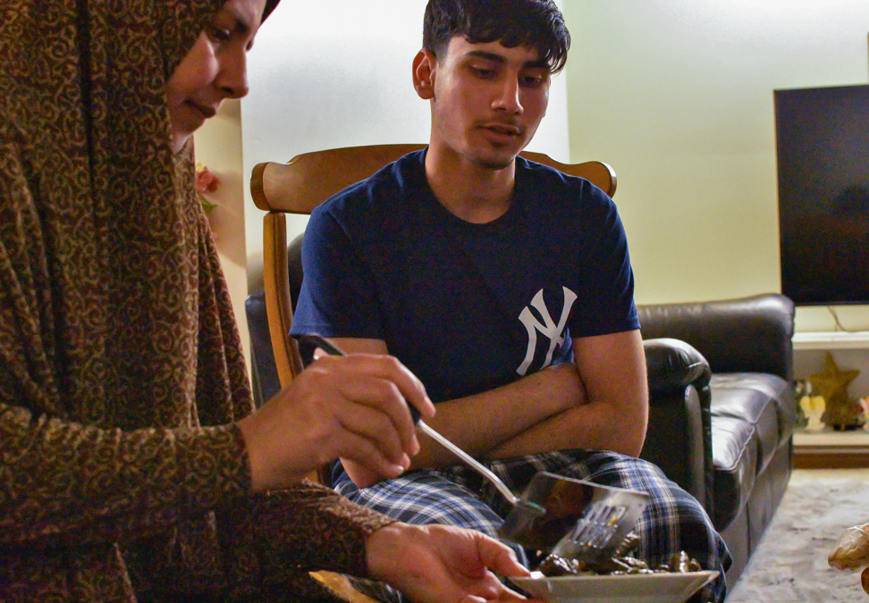 Ghusoun serves her son dolmas. A dish comprised of rice rolled up in grape leaves.