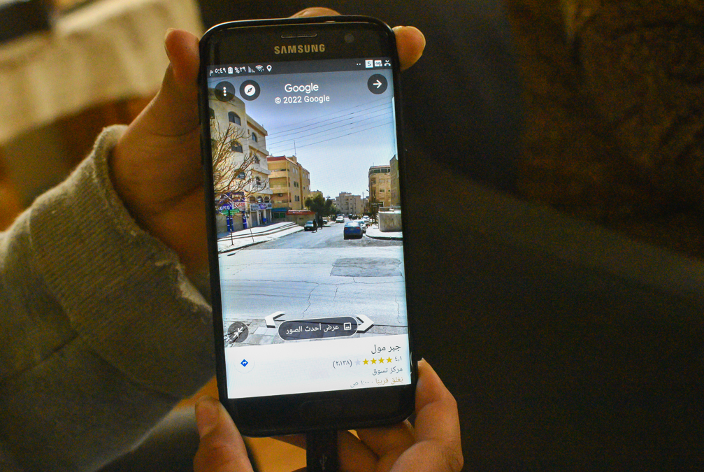 A Samsung phone displays a Google Maps street view of an apartment building in Amman Jordan