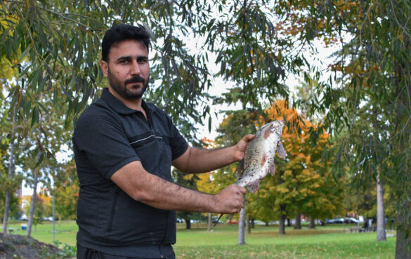 Omar Masri holds up a fish he caught at Mooney's Bay in Ottawa on October 6, 2022.