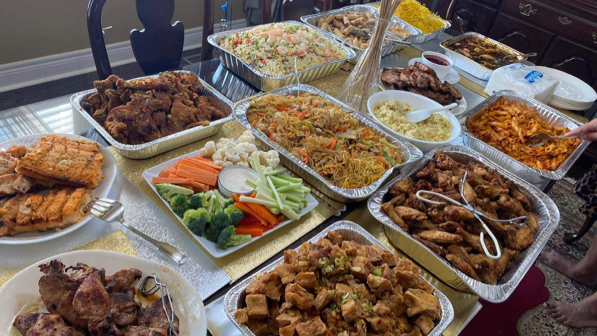 A large spread of dishes, including plates of vegetables, meats and noodles.