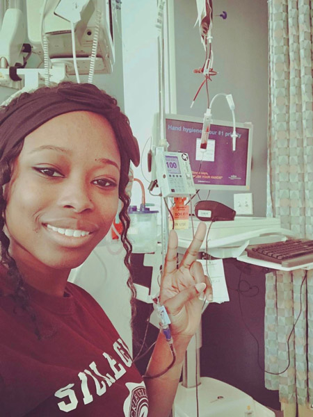 Cassandra Trimnell poses with a peace sign while getting a blood transfusion. 
