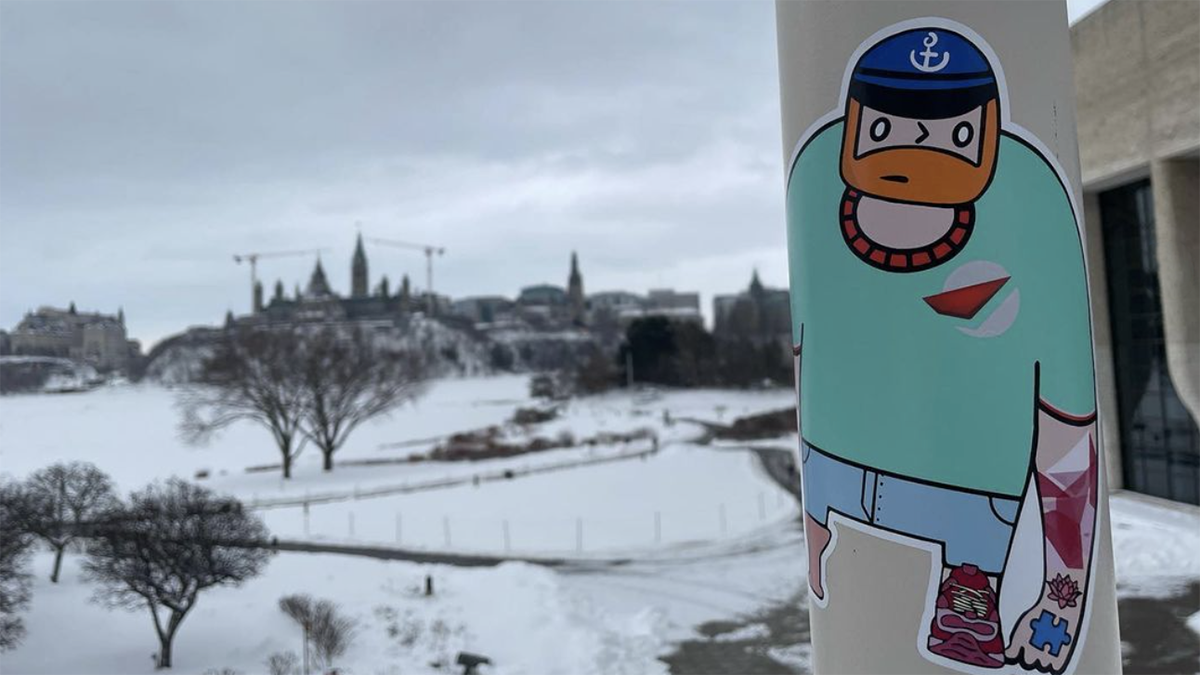 A sticker on a pole of a cartoon person with a beard and a large shirt.