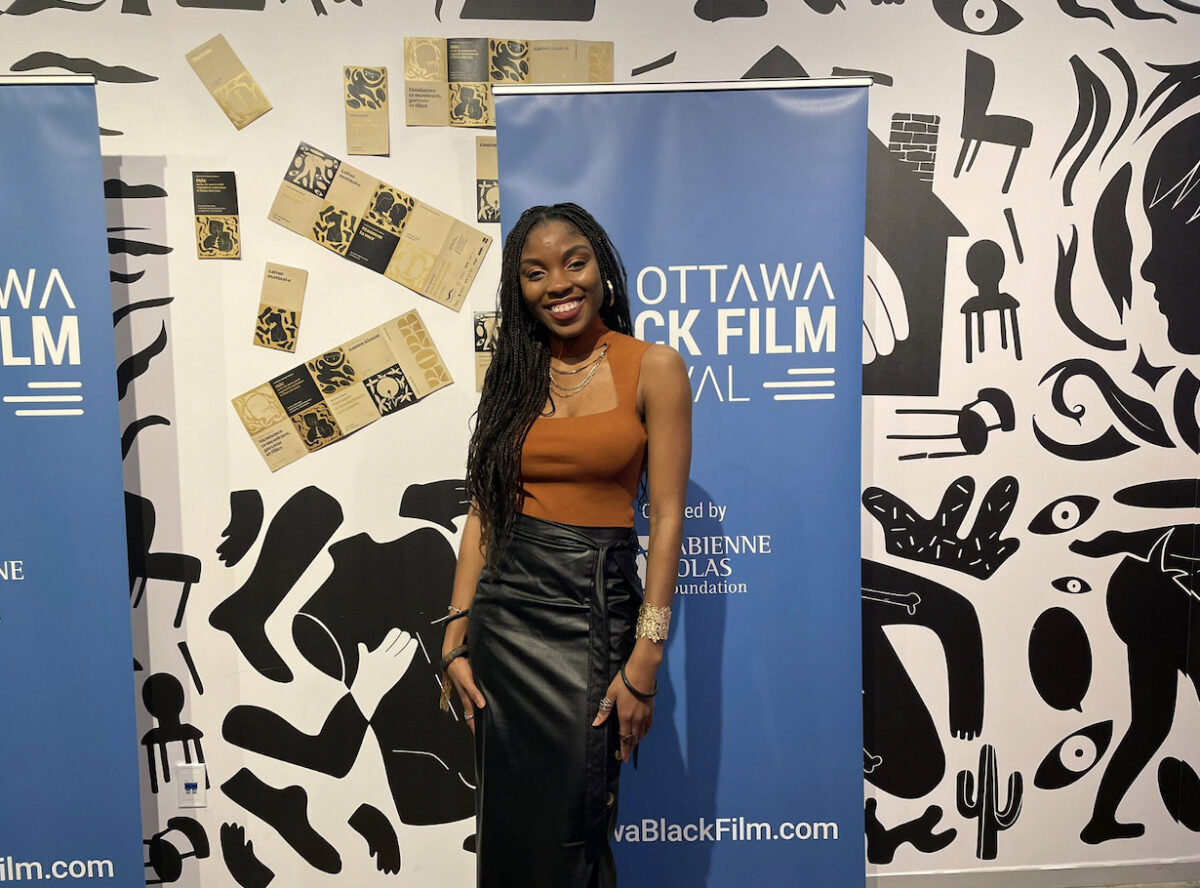 Woman stands in front of Ottawa Black Film Festival poster