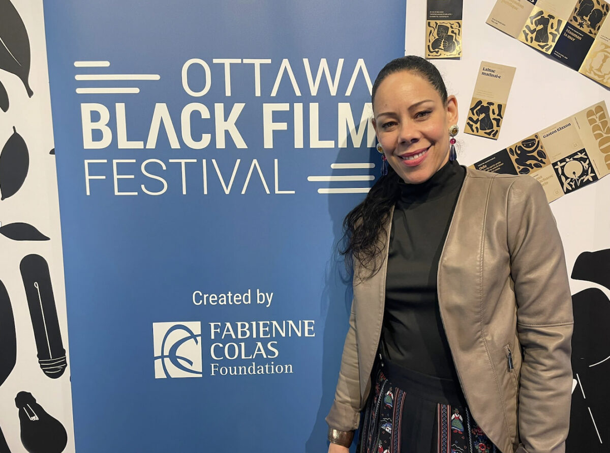 Woman stands beside Ottawa Black Film Festival poster