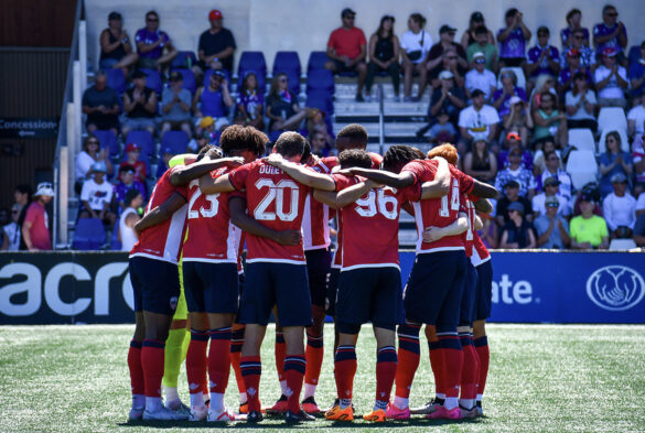 Atlético Ottawa’s starting 11 huddle up before kickoff to discuss strategy against Pacific FC at Starlight Stadium in Langley, B.C. on Aug. 13.