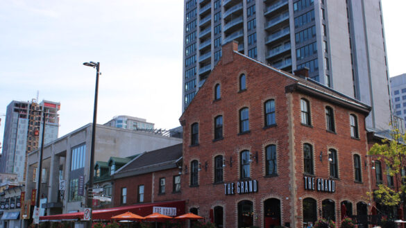 A wide shot of the building that houses The Grand Pizzeria and Bar.