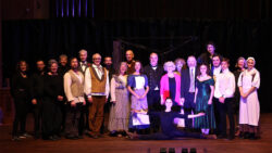 The cast of New Opera Lyra's production of Frankenstein pose together on stage after a performance.