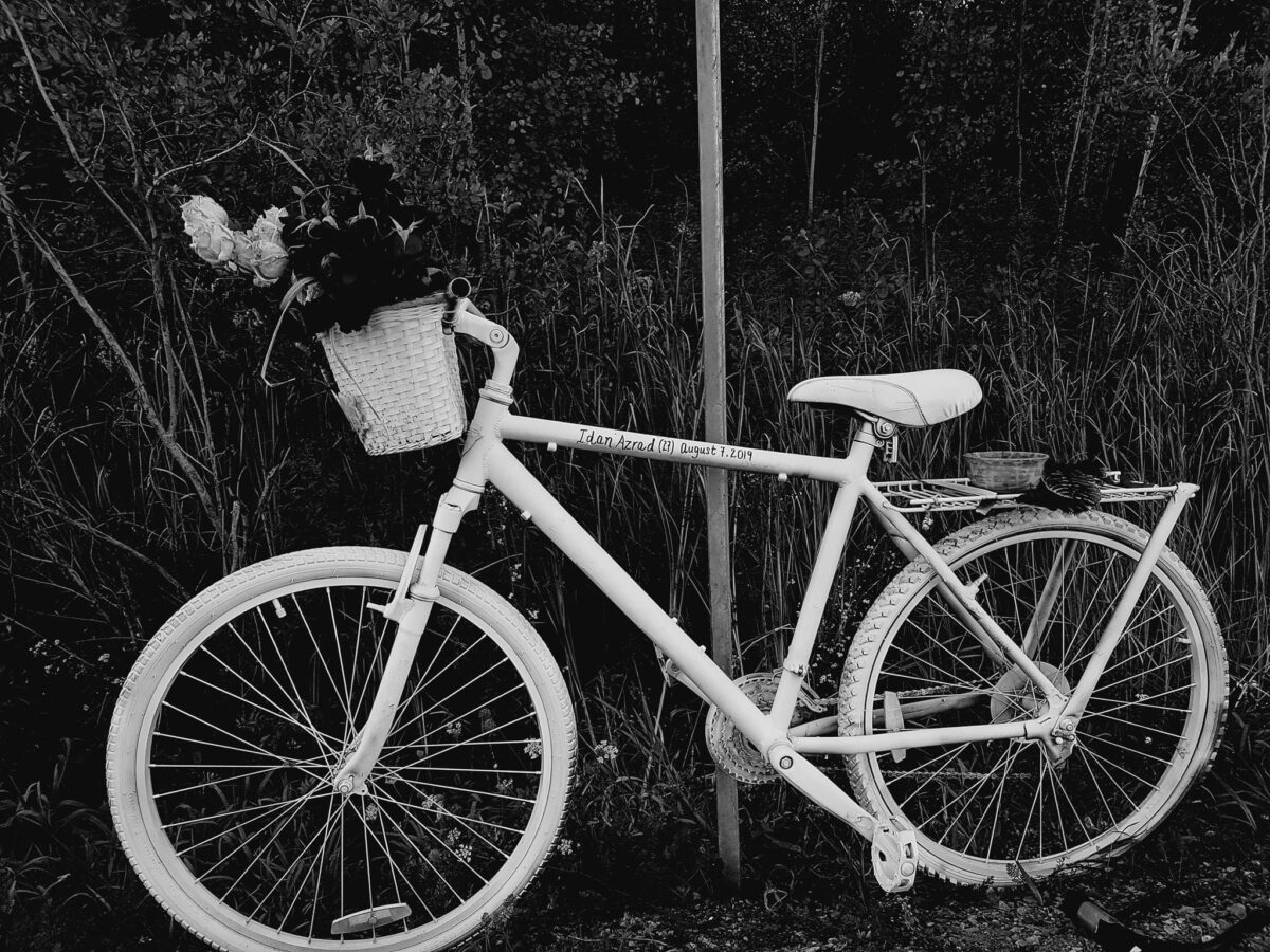 A black and white photo of a ghost bike.