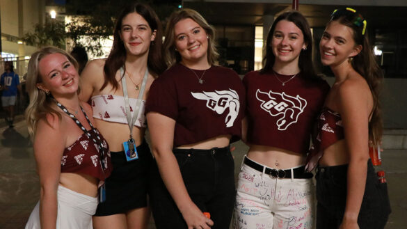 Five girls stand next to each other wearing white and burgundy University of Ottawa Gee-Gees merch.