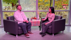 Photo of show hosts; two people sitting in an interview set.