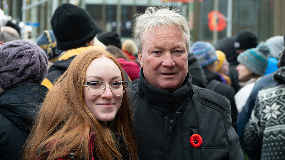 Ian McKechnie and his daughter stand together smiling at the National Remembrance Day Ceremony in Ottawa.