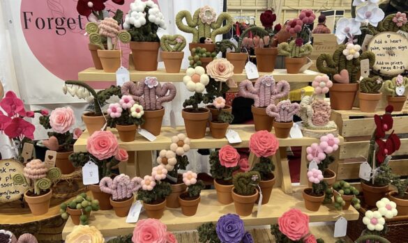 Several rows of replica plants and flowers made from macrame on display at market