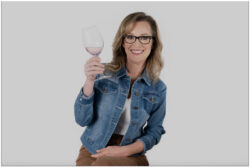 Smiling woman sitting alone raises wine glass