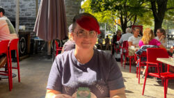 Woman smiling and sitting on the patio at a restaurant.