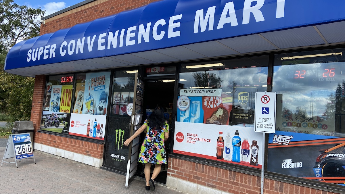 A woman enters a convenience store. 