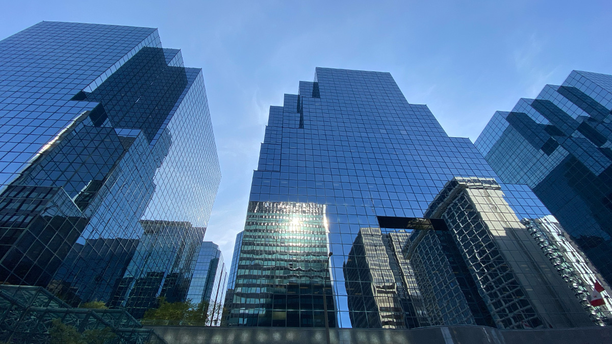 Photo of high rise buildings reflecting other buildings in their windows.