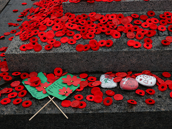 Poppies and other trinkets cover the base of the Tomb of the Unknown Soldier. 