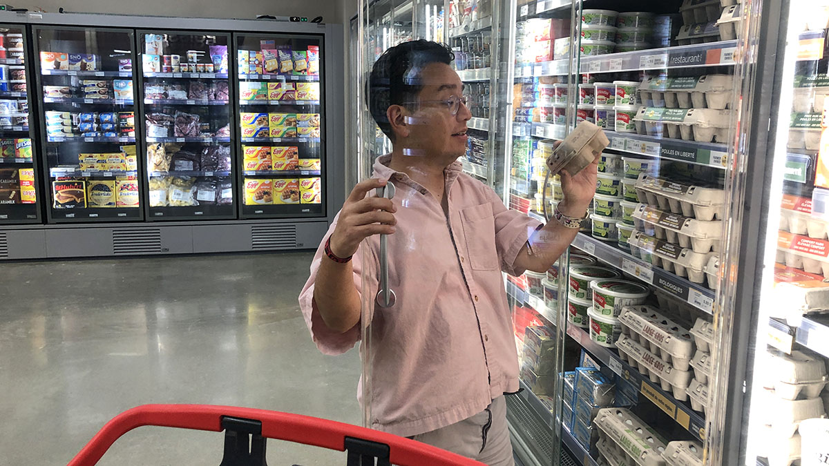 Shopper shopping for eggs in a grocery store. 