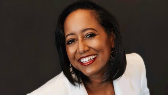 Dr Christina Romulus smiles at the camera wearing a a white blouse.