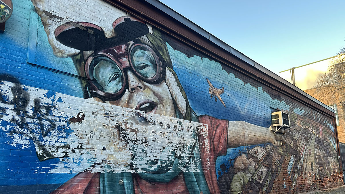 A mural splashes the side of Little Victories