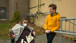 Sarah Trick, left, sits in her wheelchair next to Caelan Monkman, right. They are at the bottom of a ramp outside.