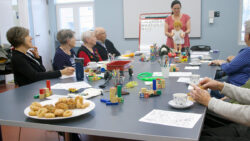 A group meets in a meeting room to reminisce on their youth. On the table are toys and games.