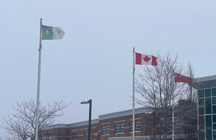 Franco-Ontarian flag and Canadian flag outside of a school.