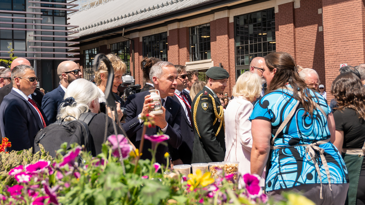 Prime Minister Mark Carney holds up a bottle of maple syrup.