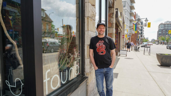A restaurant owner stands outside his business.