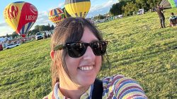 Traina taking a selfie in front of hot air balloons.