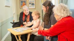 A child and their mother complete educational activity with two senior women.