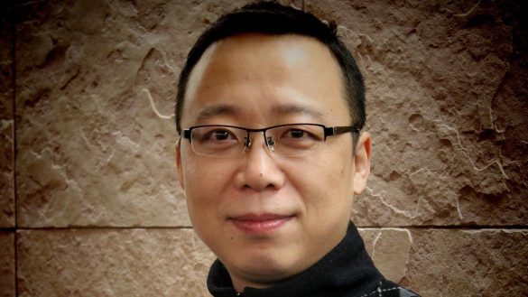 Man stands in front of stone wall