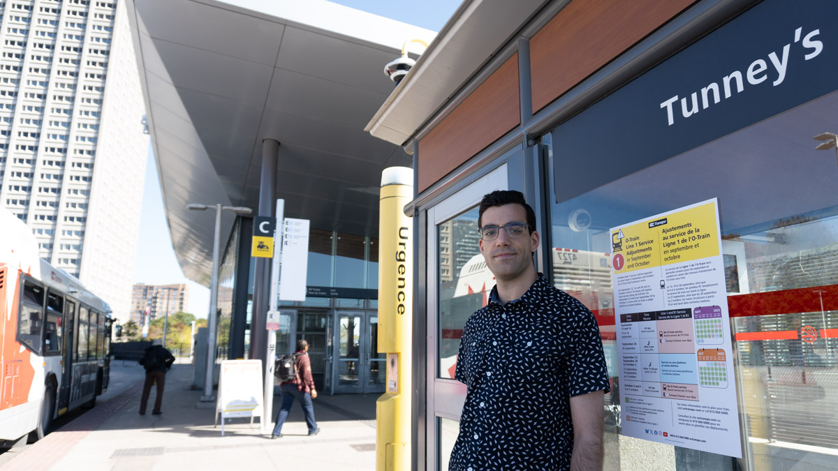 Gio Petti, the documentary filmmaker of "Dude, Where's My Bus?" standing in front of the night stop at Tunney's Pasture.